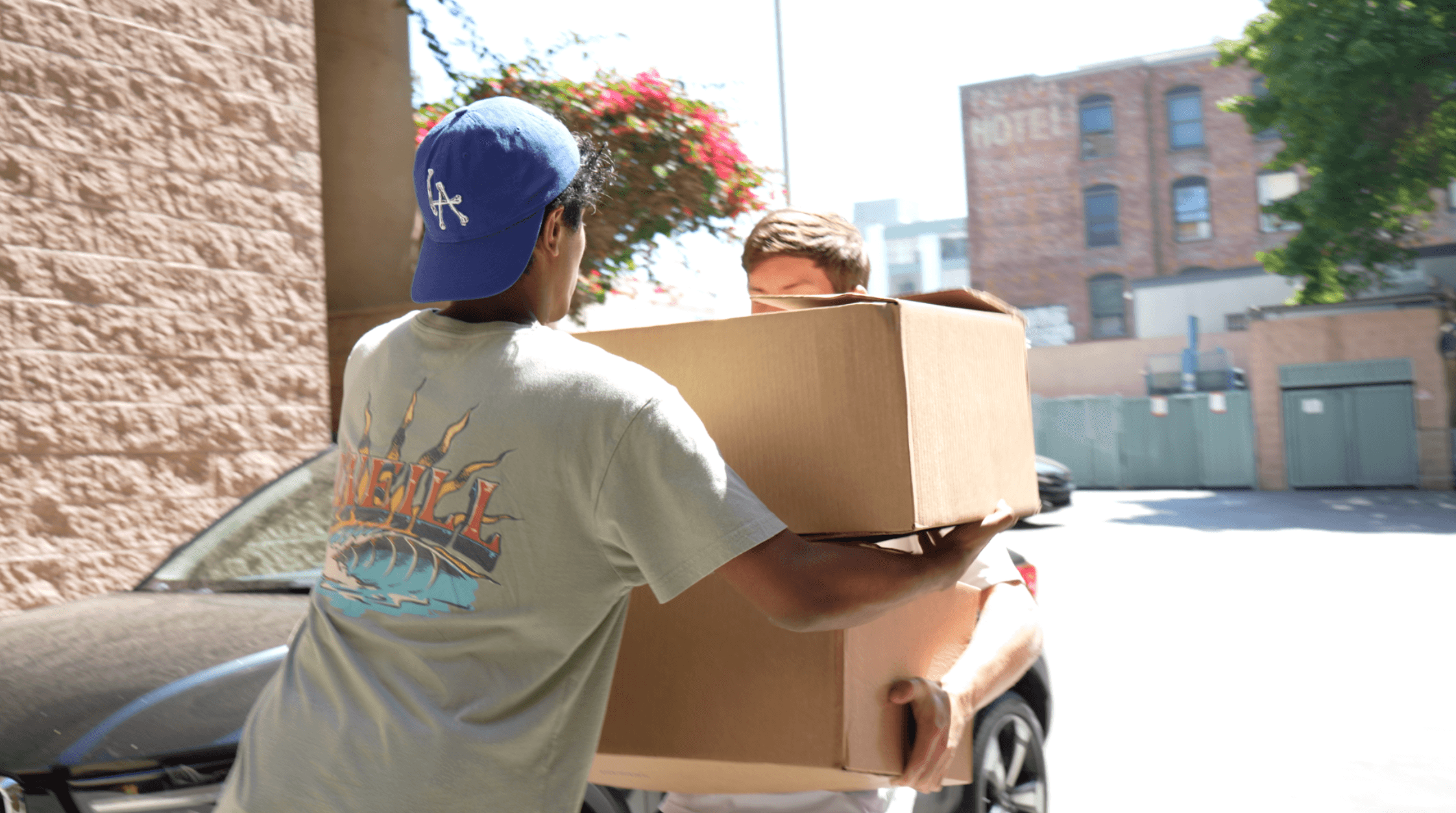 KneadLA volunteers carrying boxes of rescued baked goods